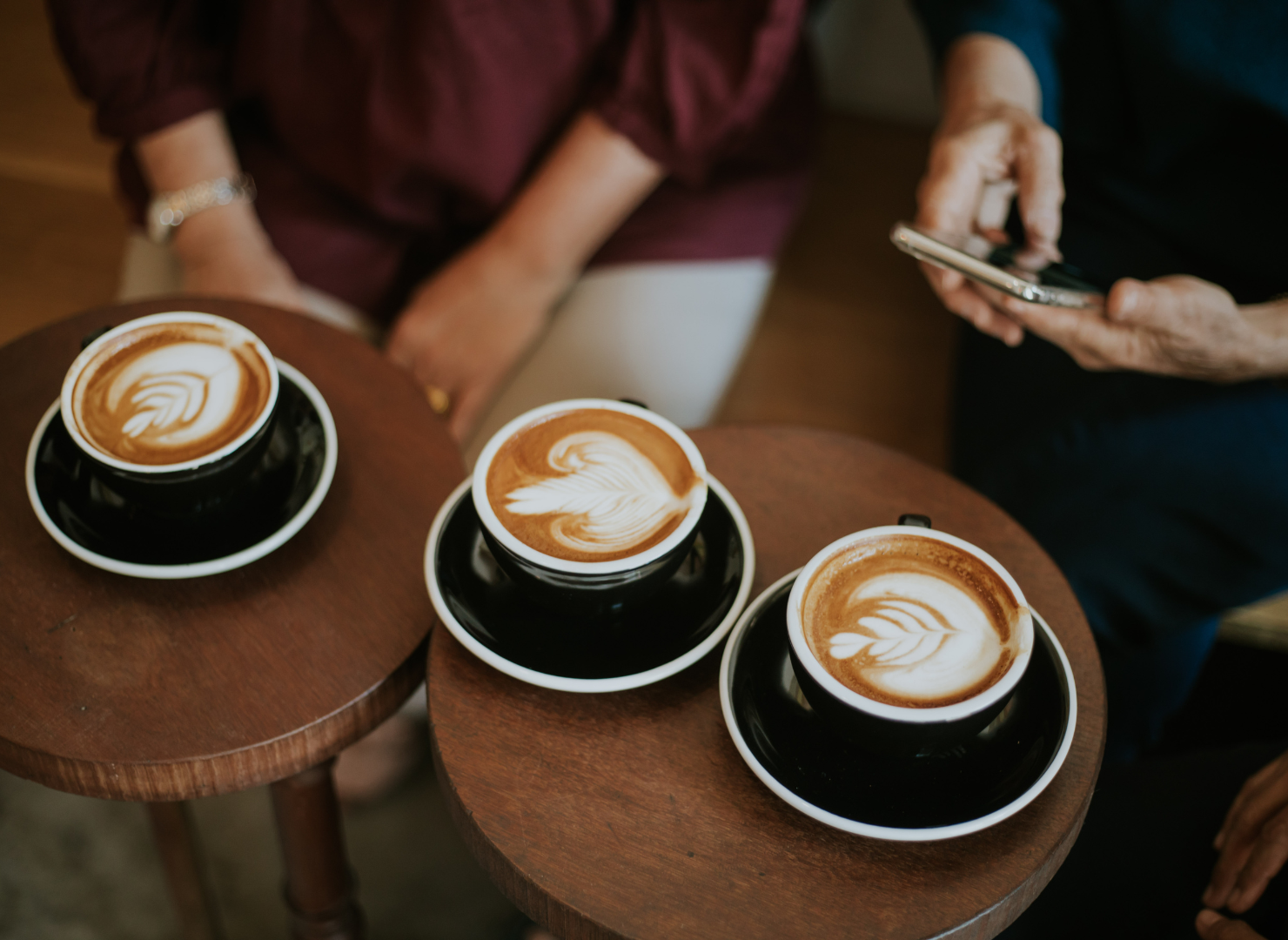 3 kopper kaffe ved siden af hinanden på træborde.
