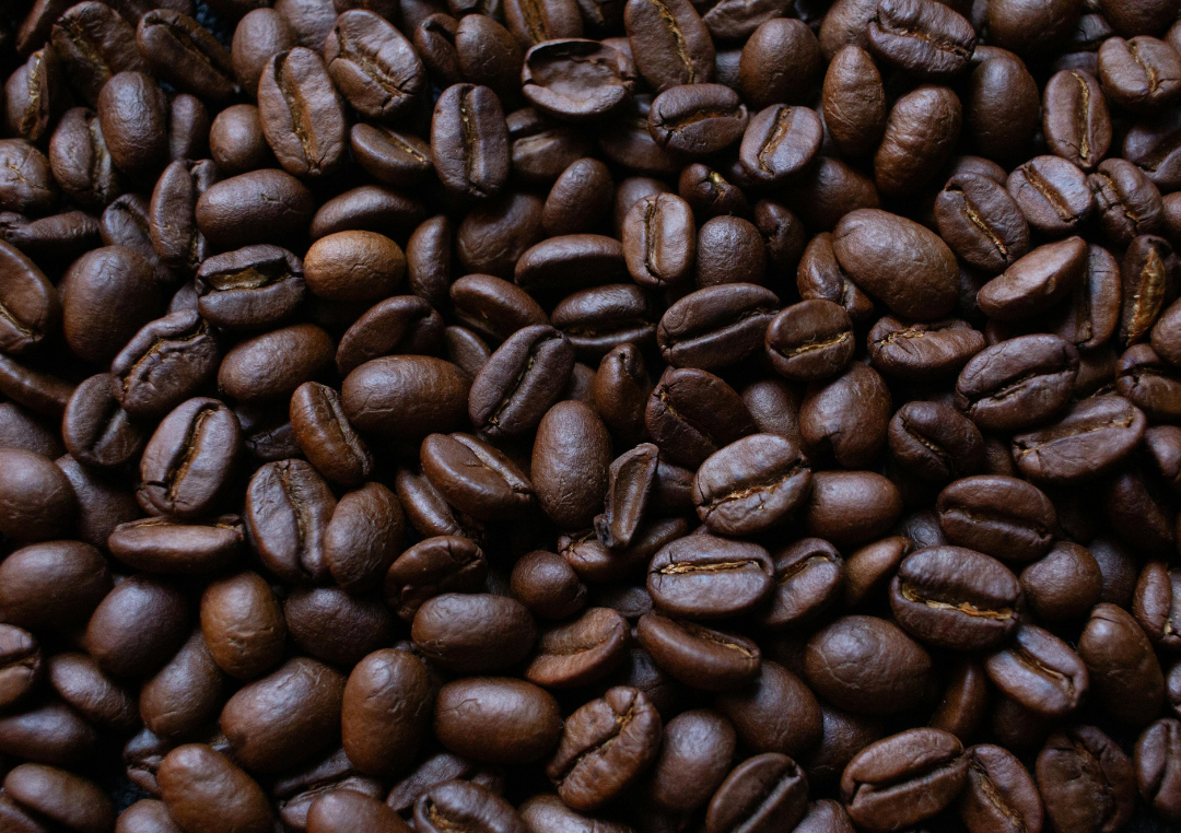 En masse mørkristet kaffebønner ligger sammen