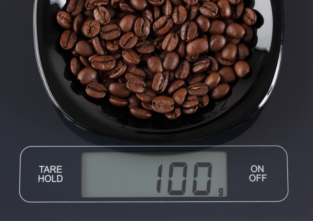 100g kaffebønner på en digital vægt