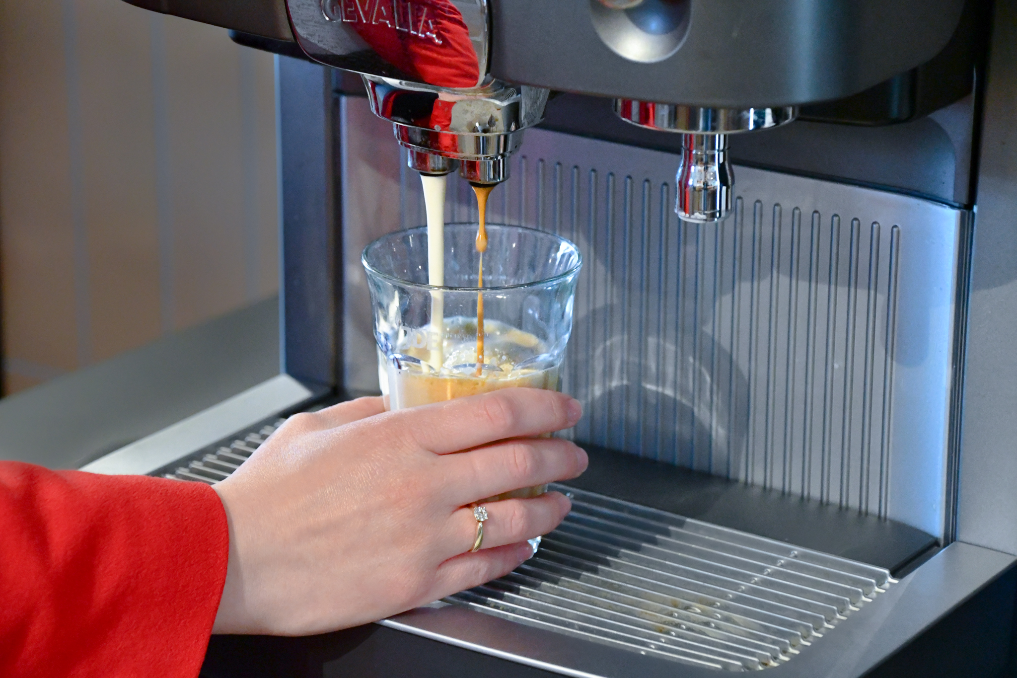 Kvinde tager kaffe fra cafitesse maskine
