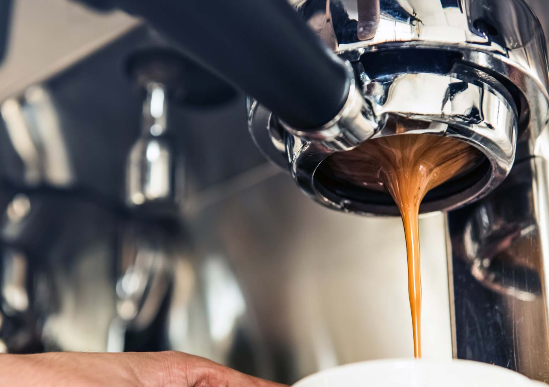 Kaffe brygges fra en espressomaskine ned i en kop.