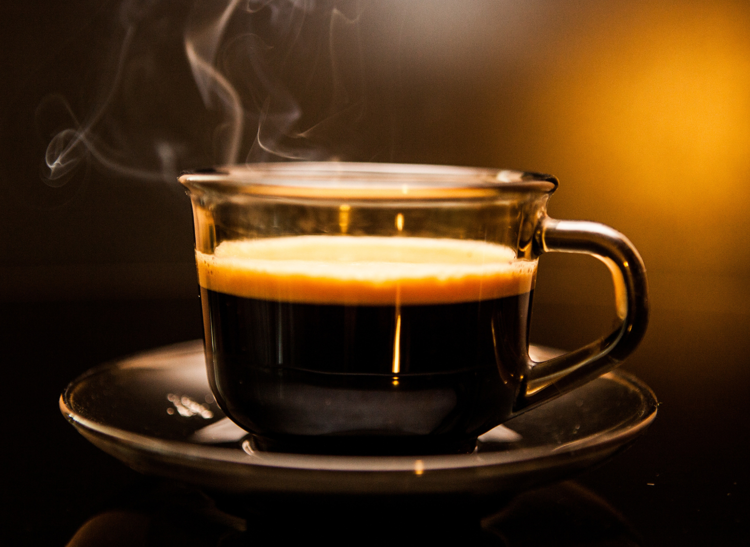Kop med sort kaffe på en underkop som er rygende varm