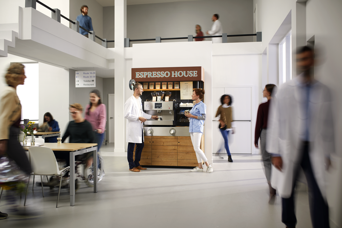 Åben caféområde med Espresso House-station og mennesker, der går og taler.