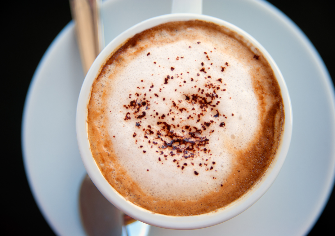 Kop kaffe set oppe fra med mælkeskum i