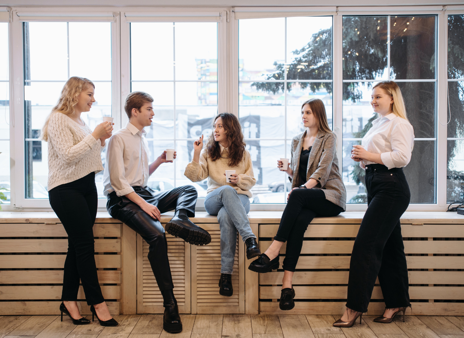 Kolleager sidder i en vindueskam med en kop kaffe hver