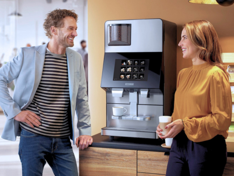 To mennesker hygger ved kaffemaskine
